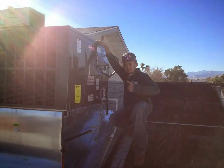 HVAC technician performing Boiler Repair on a rooftop unit in Nantucket